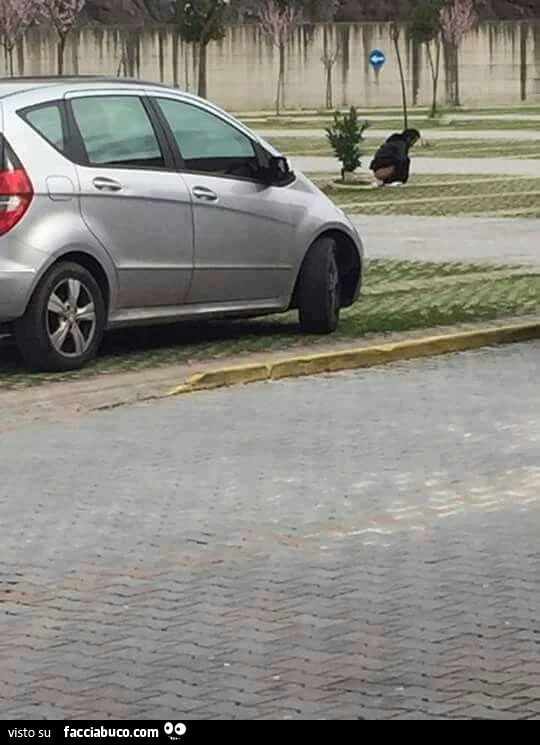 Uomo fa la cacca in un parcheggio