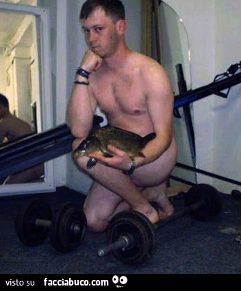 Uomo nudo con animale in mano vicino ai pesi da palestra
