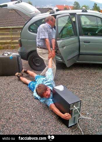 padre trascina figlio in macchina che resta attaccato al computer