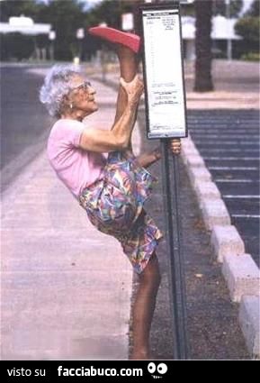 La vecchietta si stira la gamba alla fermata dell'autobus