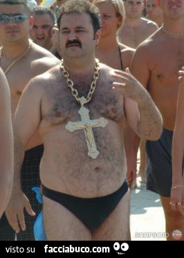 Uomo grasso in slip con croce gigante al collo