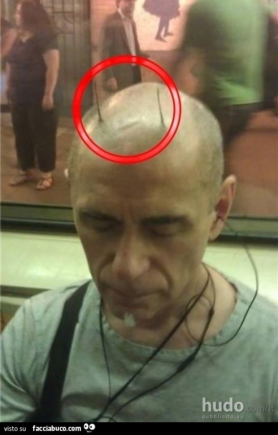 Uomo pelato con due ciocchette di capelli come corna
