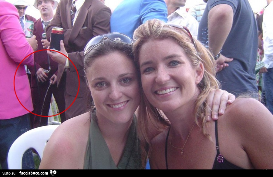 Le ragazze si fanno la foto, ma alla loro sinistra, un uomo fa la pipì